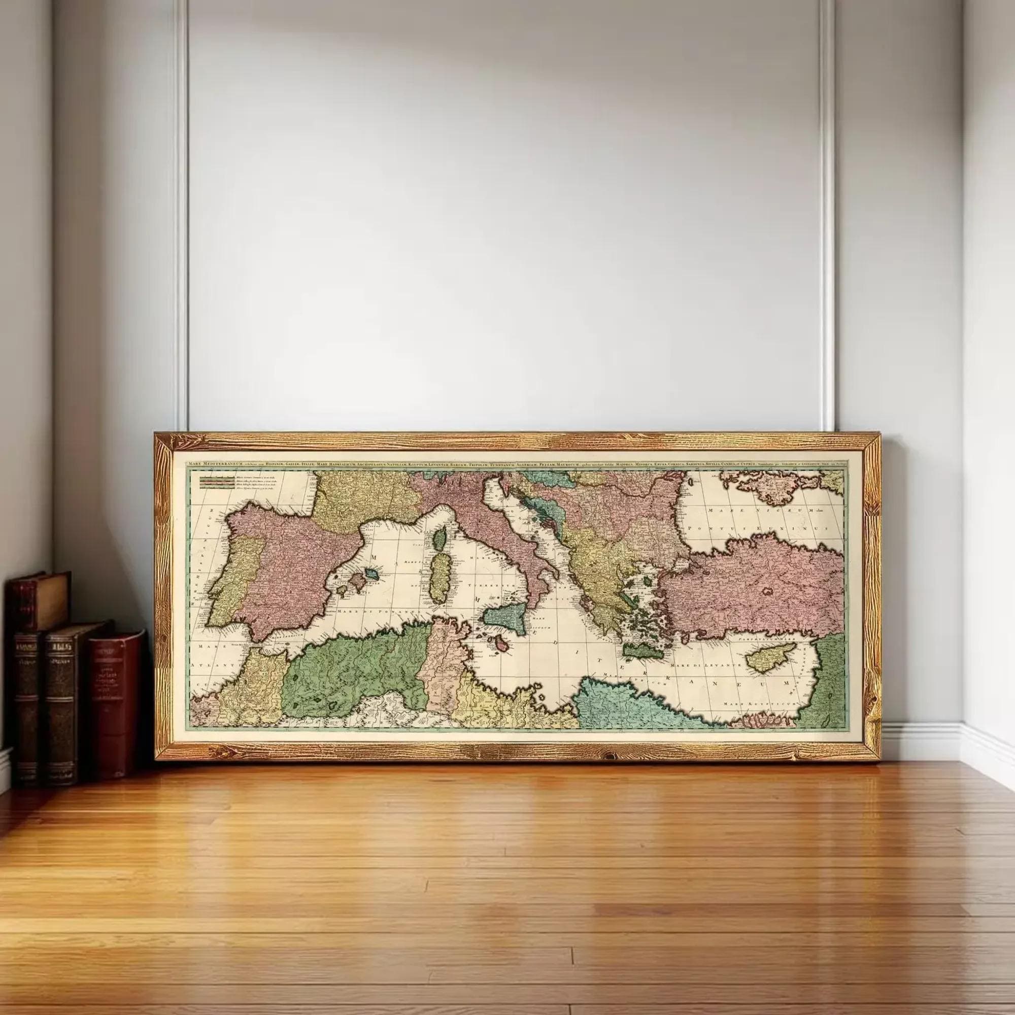 A large framed map of Europe and the surrounding areas is displayed on a wooden floor against a white wall.