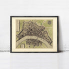 The image is a framed vintage map of a city, depicting a detailed layout of streets, buildings, and other urban features.