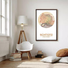 a cozy corner of a room with a white chair, a lamp, and a framed map of Richmond, Virginia.