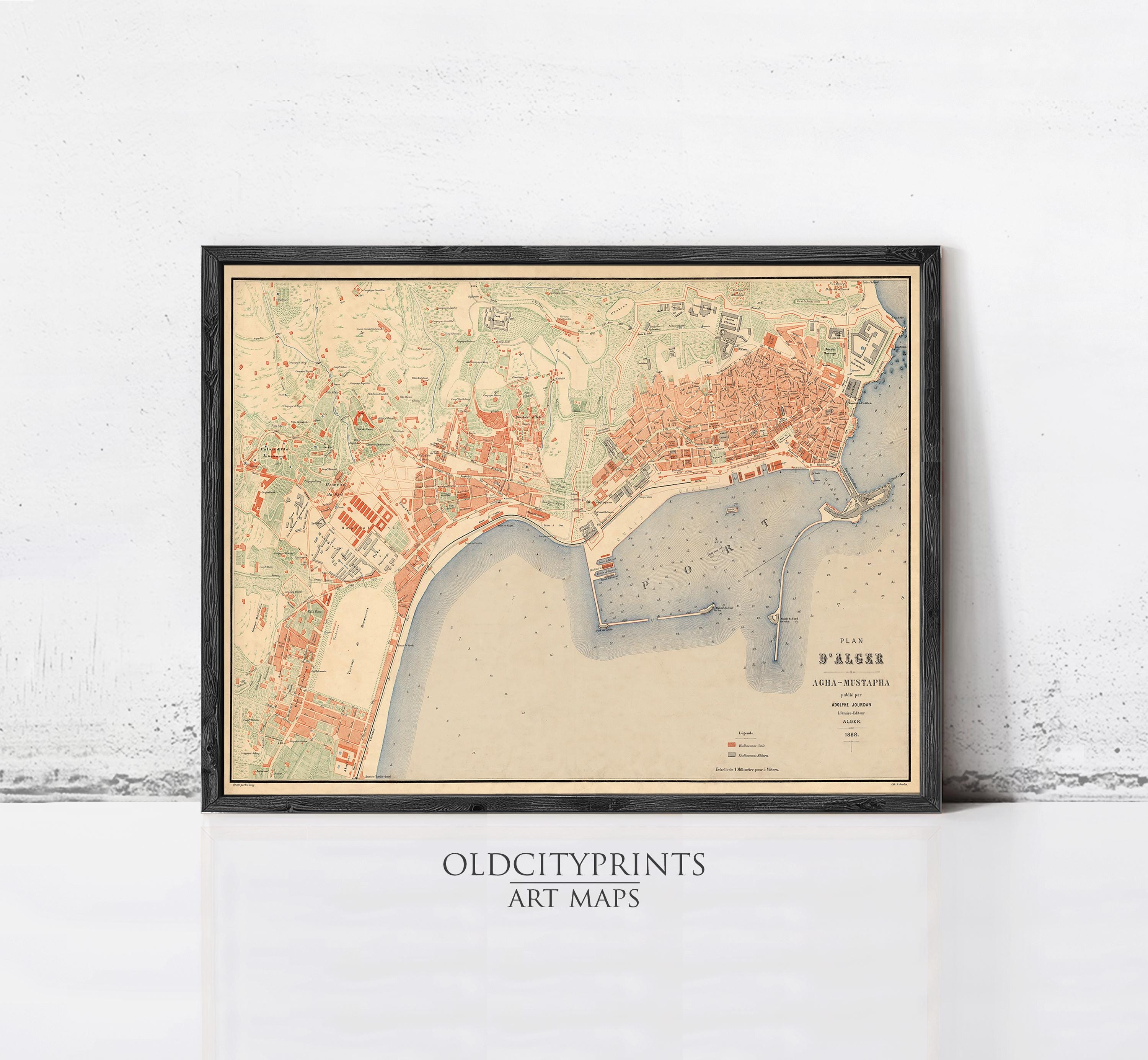 The image is a framed vintage map of a city, likely from the 19th century, displayed on a wall.