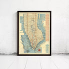 The image is a framed vintage map of New York City, depicting the city's streets and neighborhoods in a detailed and colorful manner.