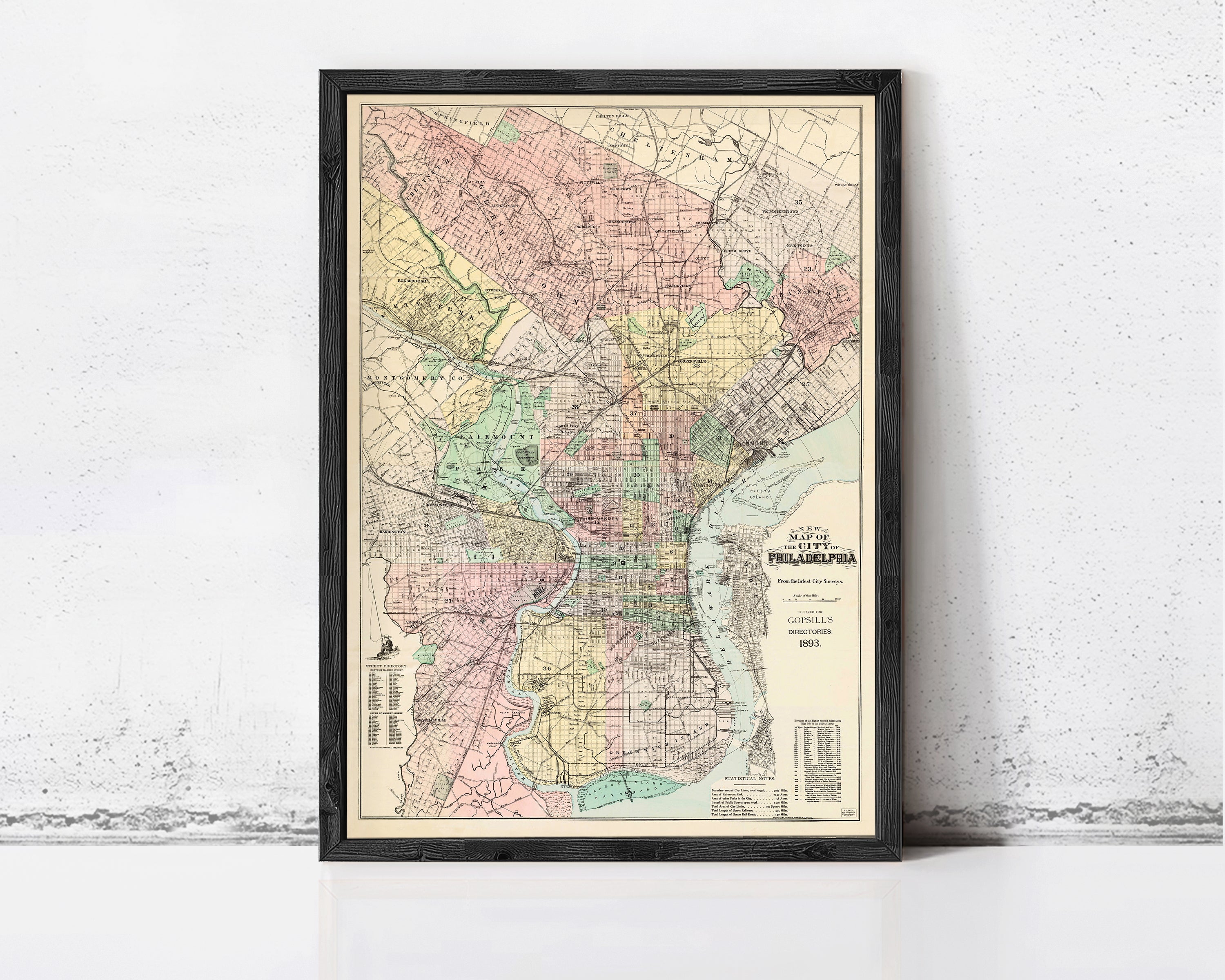 The image is a framed vintage map of Philadelphia, Pennsylvania, depicting the city's streets, neighborhoods, and surrounding areas.