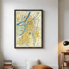 The image is a framed vintage map of a city, depicting various landmarks and streets in a detailed and colorful manner.
