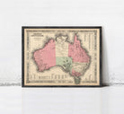 The image is a framed vintage map of Australia, depicting the country in a detailed and intricate manner.