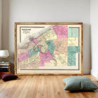 The image is a framed vintage map of Cleveland, Ohio, depicting the city's streets and neighborhoods in a colorful, detailed manner.