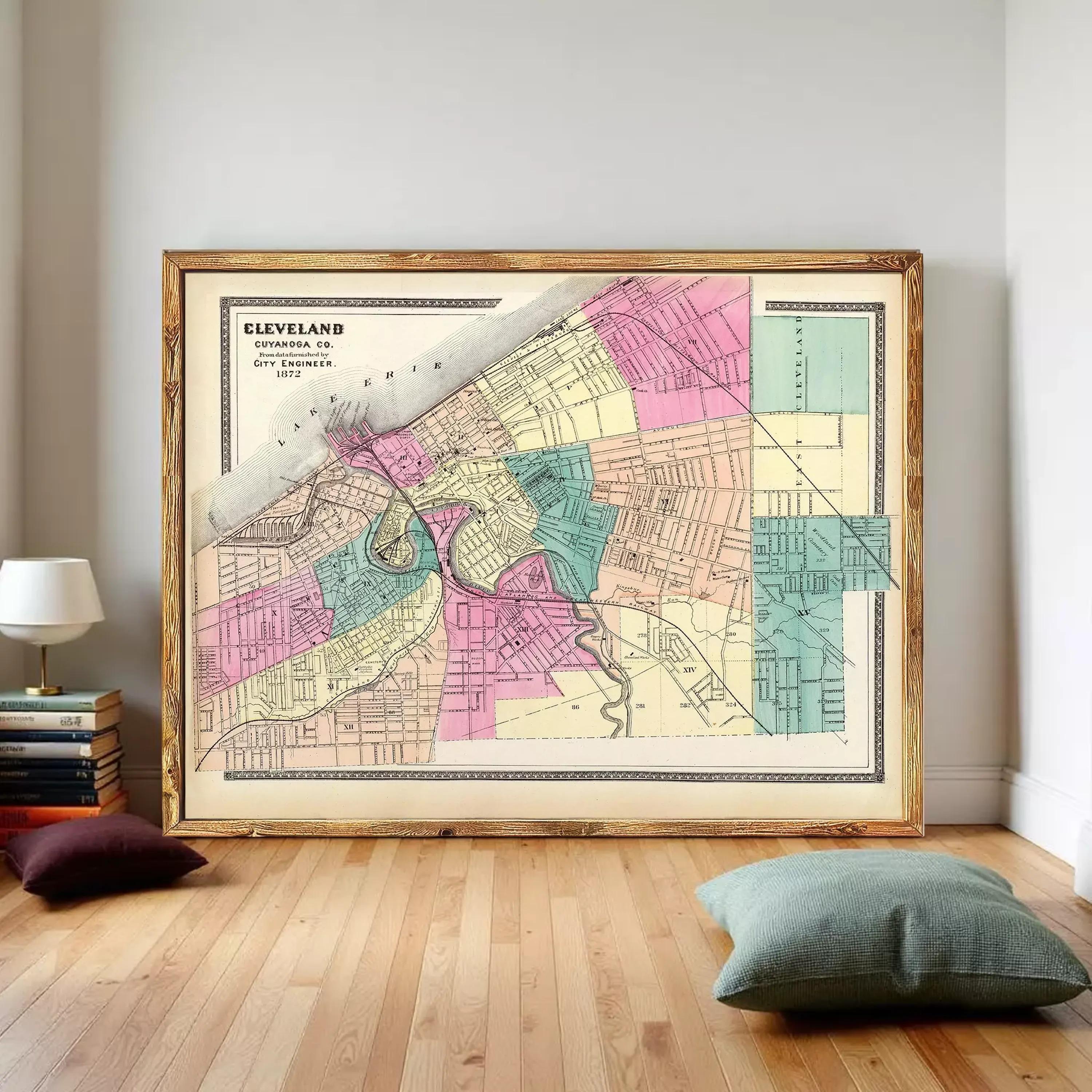 The image is a framed vintage map of Cleveland, Ohio, depicting the city's streets and neighborhoods in a colorful, detailed manner.