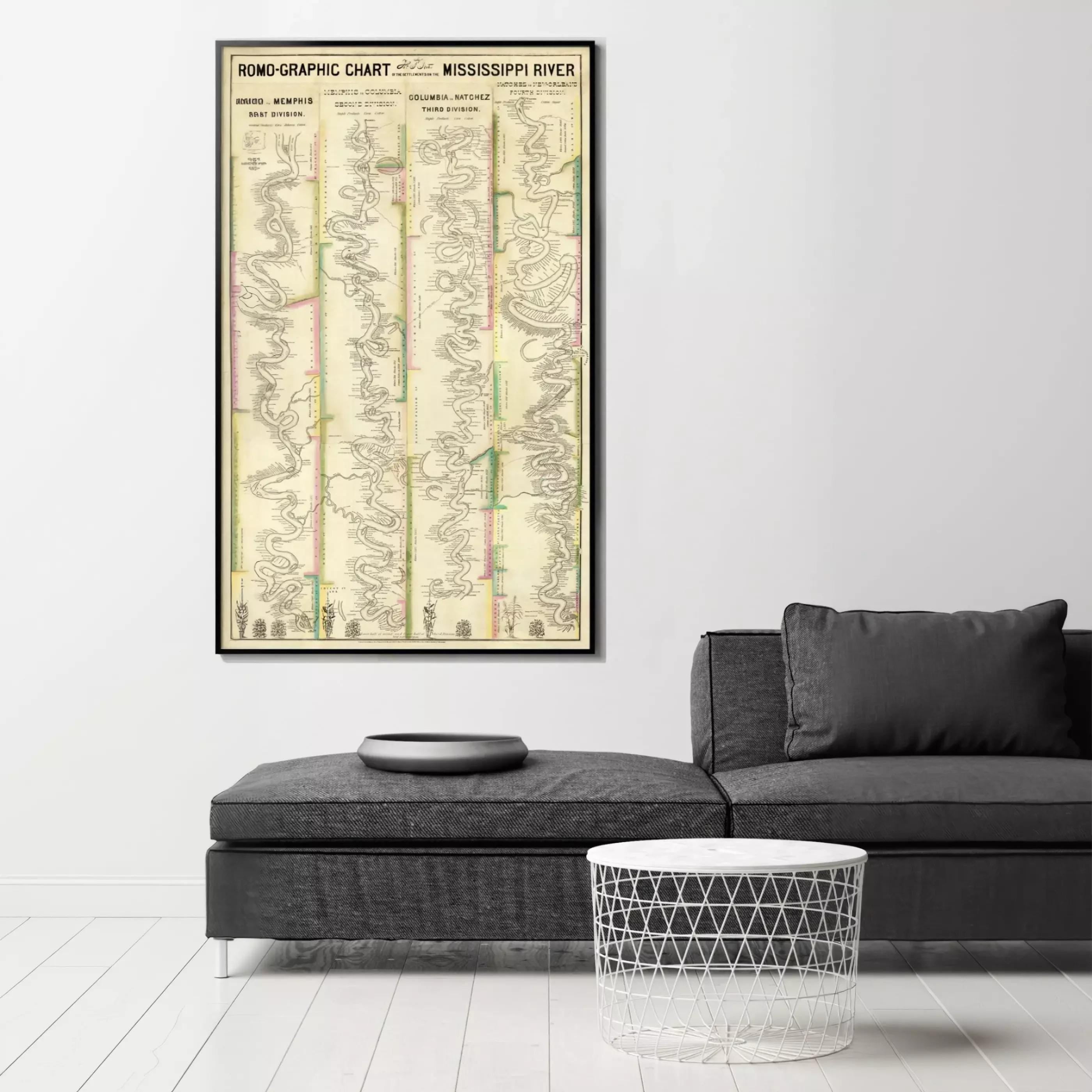 a large framed map of the Mississippi River hanging on a wall, with a gray sofa and a round table in the foreground.