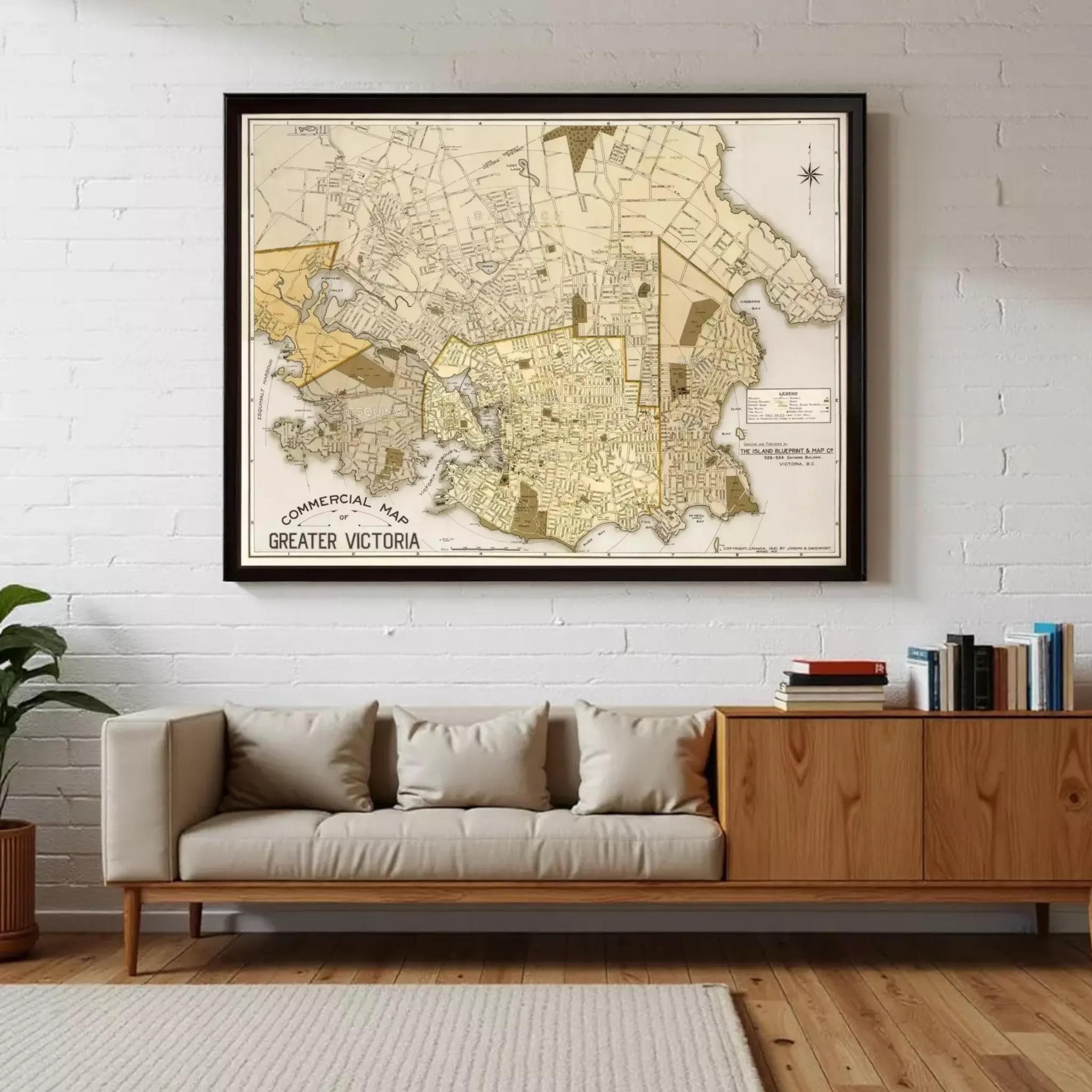 a large framed map of Greater Victoria, a map of Victoria, Australia, hanging on a white brick wall above a beige sofa in a living room.