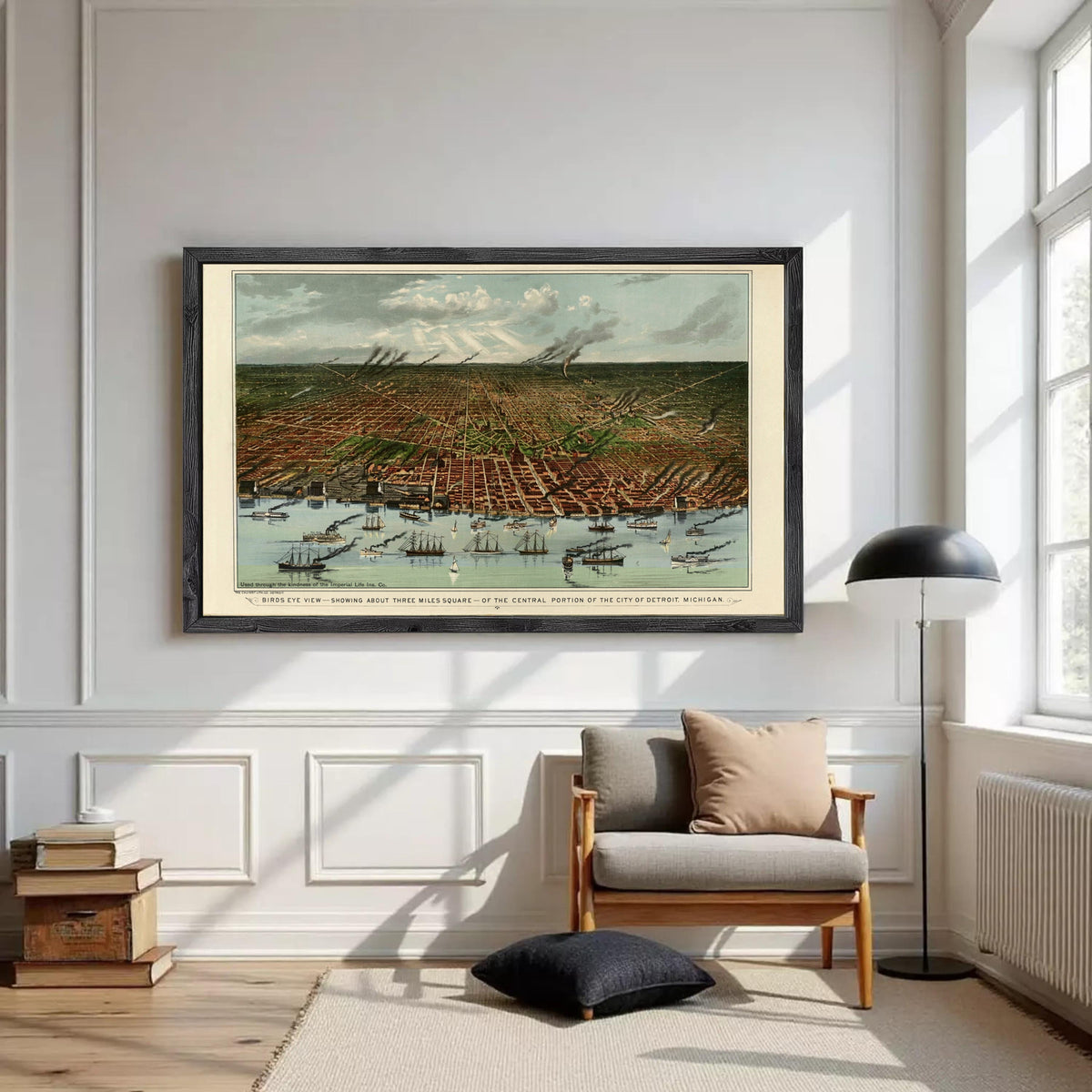 a large framed painting of a cityscape hanging on a white wall in a room with a wooden floor and a chair.