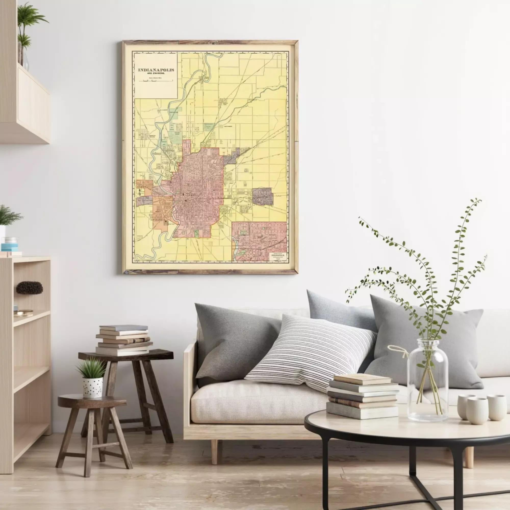 a living room with a large framed map of Idaho on the wall, a wooden coffee table with books and a vase of greenery, and a gray sofa with pillows.