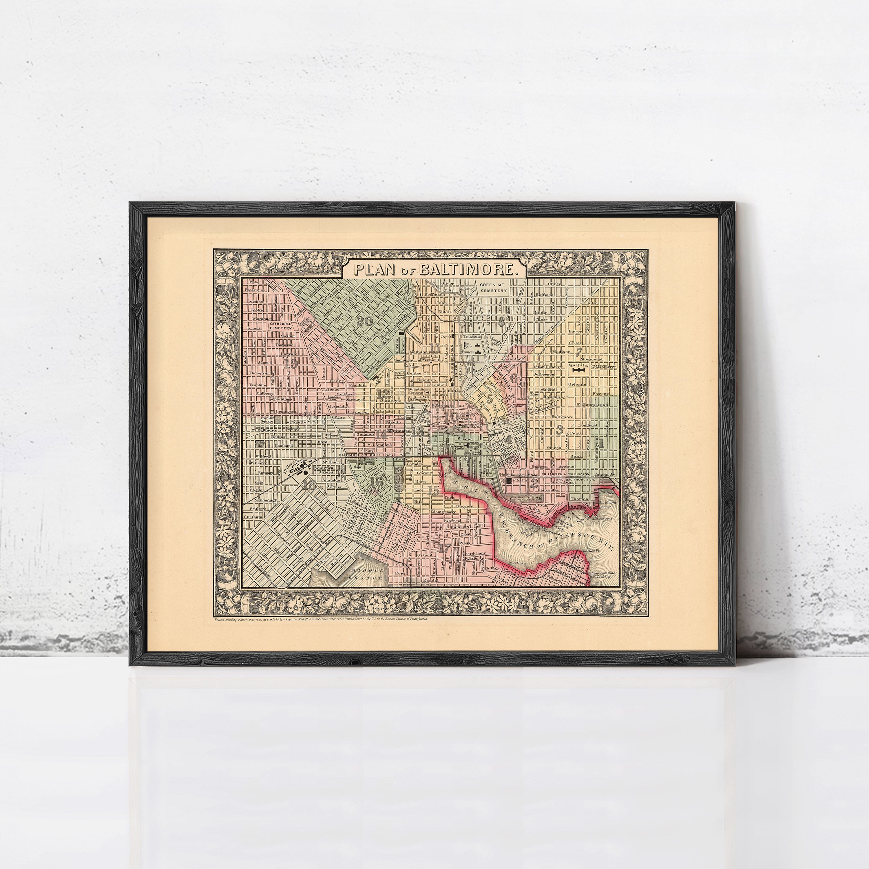The image is a framed vintage map of Baltimore, Maryland, depicting the city's streets and neighborhoods.
