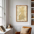 a cozy corner of a room with a large framed map of Finland hanging on the wall, a bookshelf filled with books, and a comfortable chair in the foreground.