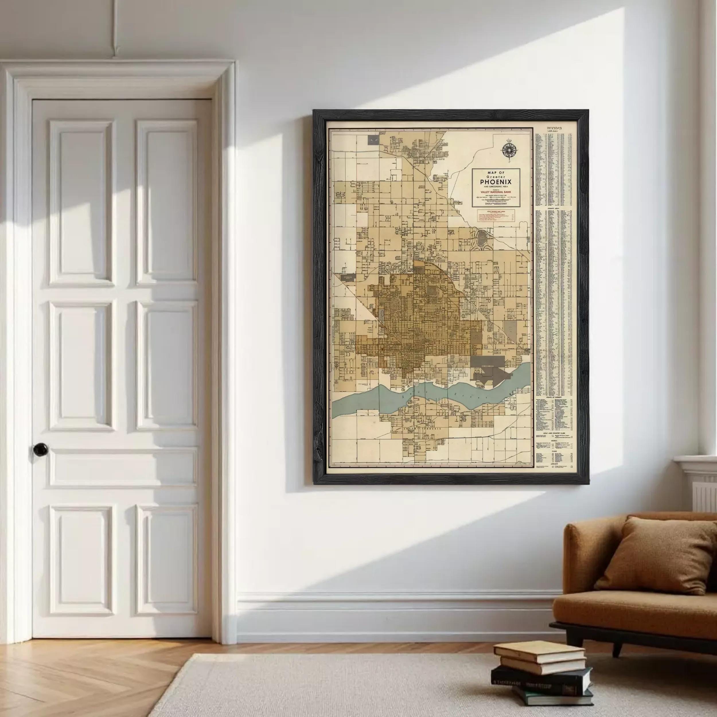 a large framed map of Phoenix, Arizona, hanging on a white wall in a room with a door and a couch.