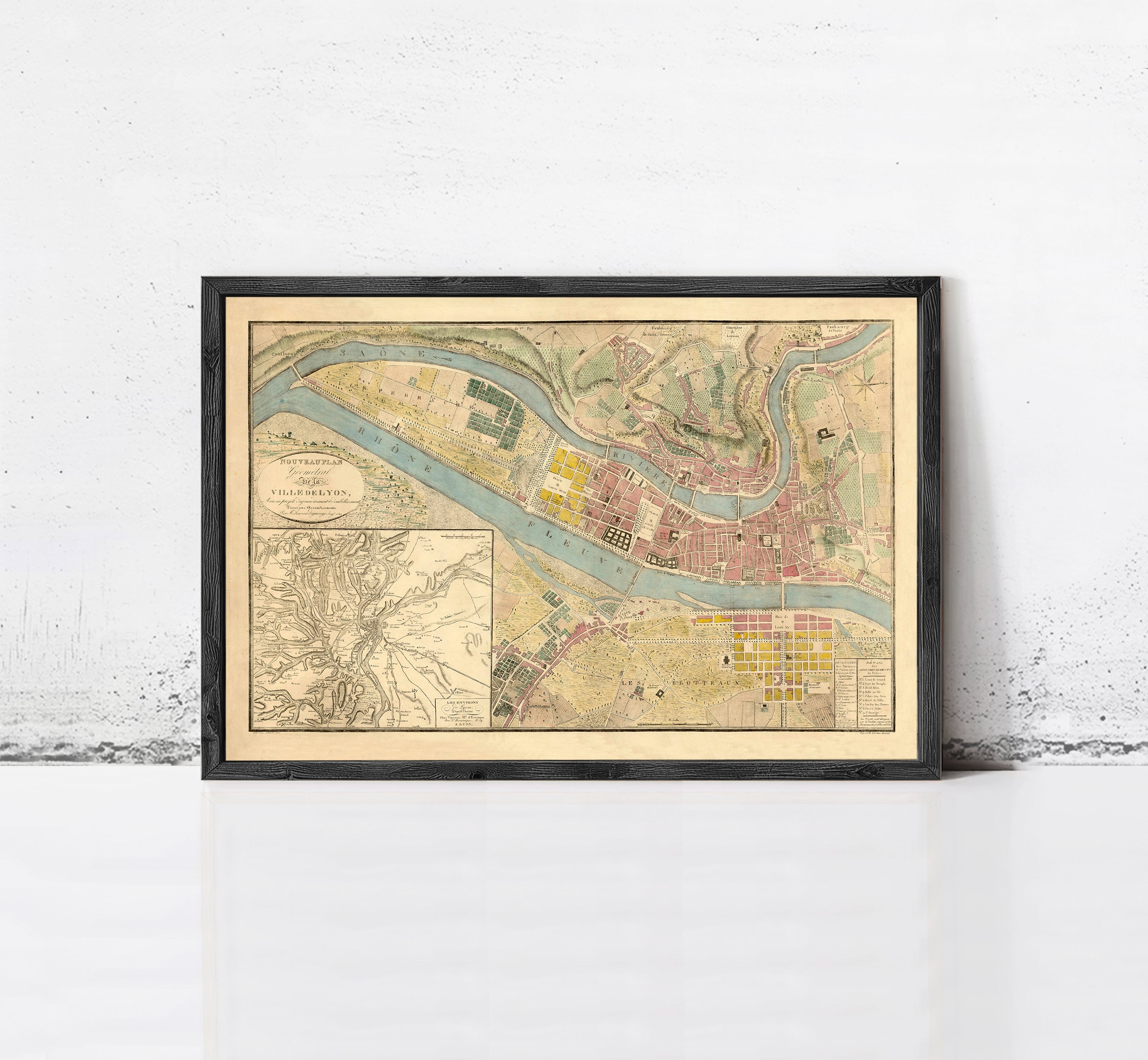 The image is a framed vintage map of a city, depicting a detailed layout of streets, buildings, and other urban features.