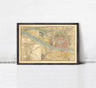The image is a framed vintage map of a city, depicting a detailed layout of streets, buildings, and other urban features.
