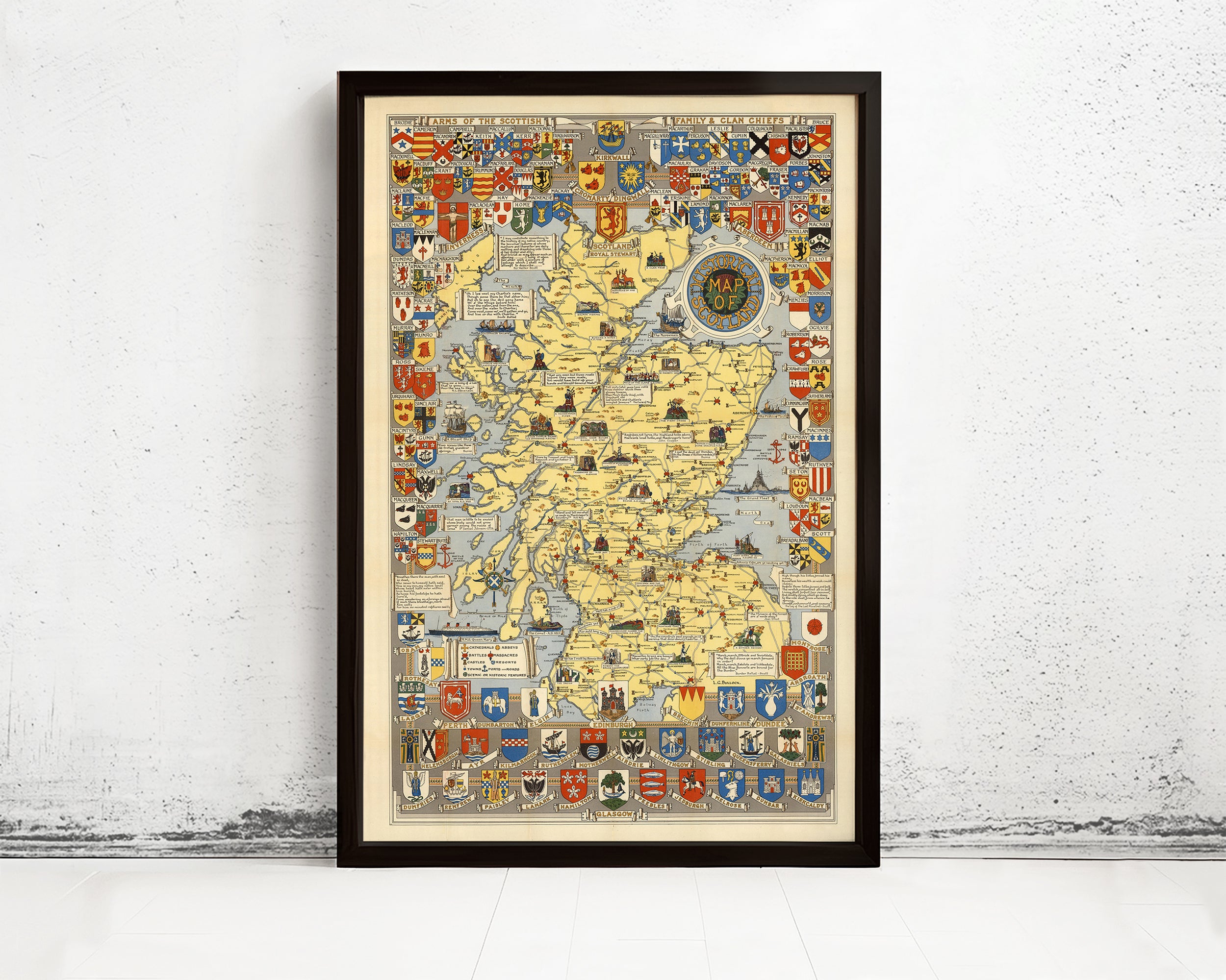 The image is a framed map of Scotland, featuring various symbols and coat of arms from different regions and countries.