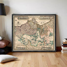 The image is a framed vintage map of Europe, depicting various countries and regions with intricate details and labels.