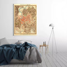 a bedroom setting with a bed, a nightstand, and a lamp. The bed has a blue blanket and a gray blanket on it. The nightstand has a lamp on it. The lamp is positioned next to the bed. The wall behind the bed has a framed map of Rome, which is titled "Pieta di Roma".