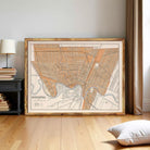 a large framed map of the city of Winnipeg, with a wooden floor and a lamp in the background.
