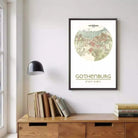 a framed map of Gothenburg, a city in Sweden, hanging on a wall above a wooden cabinet or dresser.