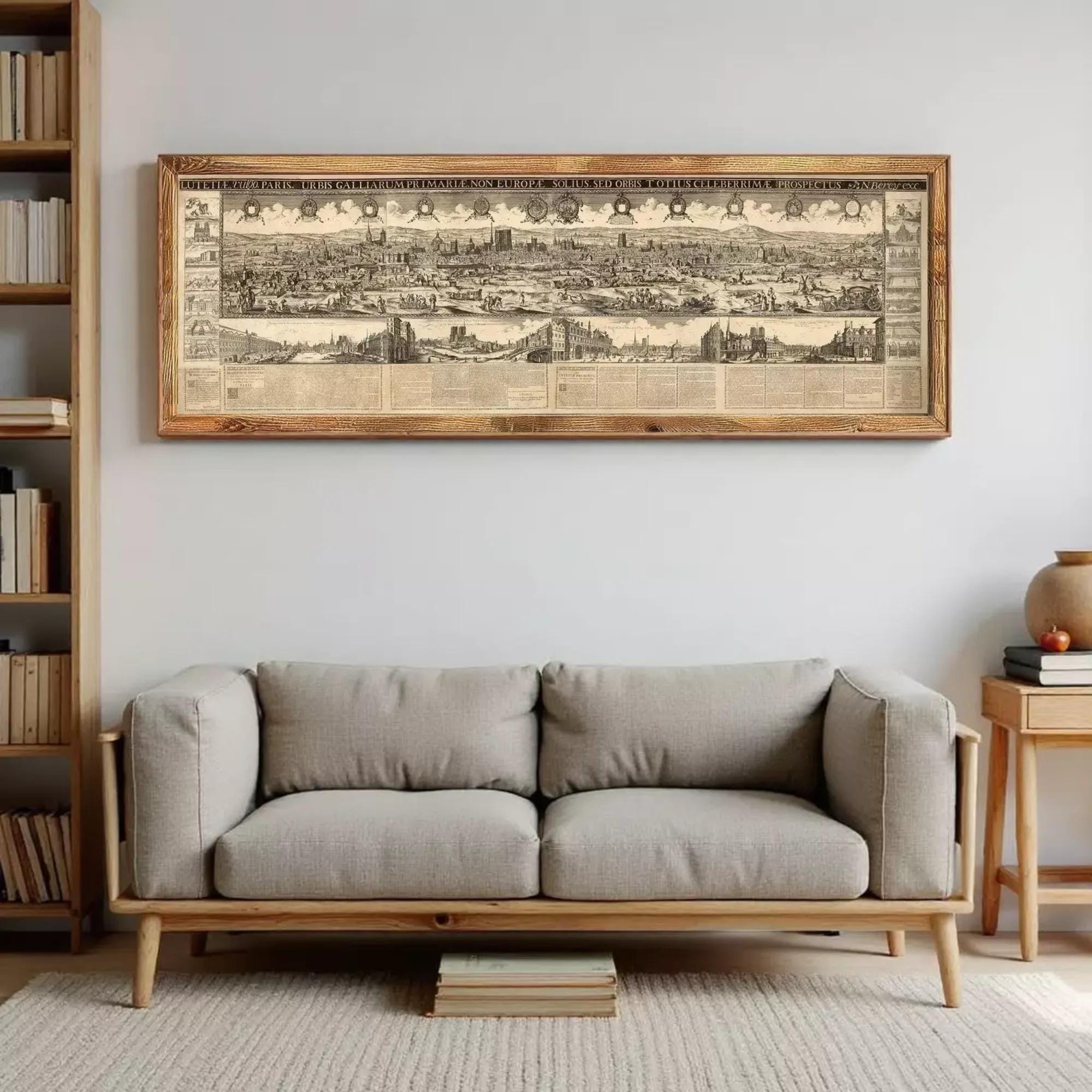 a large, framed map of a city hanging on a wall above a gray sofa in a living room.