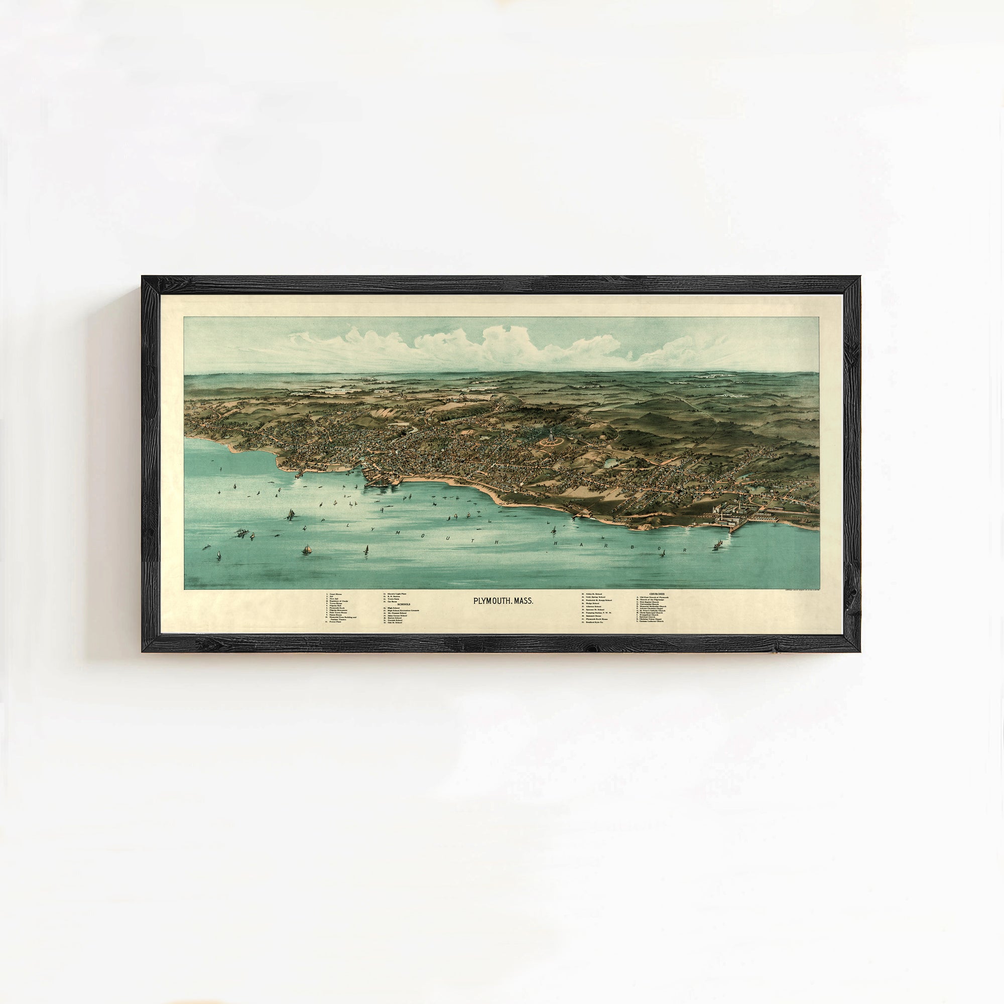 The image is a framed aerial map of a coastal city, depicting the city's layout, coastline, and surrounding areas.