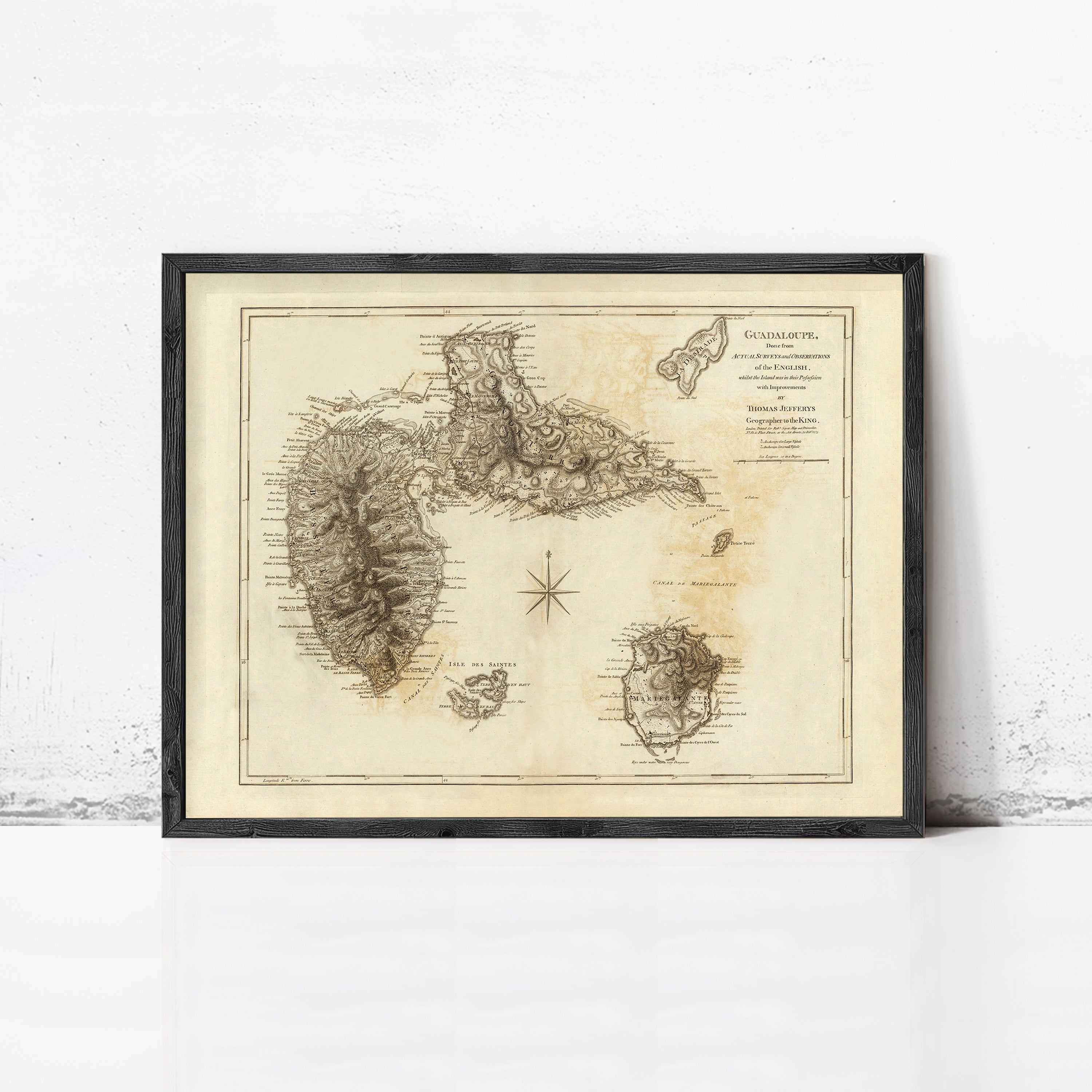 The image is a framed antique map of the Guadeloupe archipelago, which is a group of islands located in the Caribbean Sea.