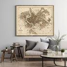 a large framed map of Rome hanging on a wall above a couch with pillows and a coffee table in a living room setting.