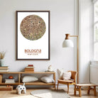 a living room with a large framed map of Bologna hanging on the wall. The room has a wooden floor, a wooden bookshelf, a wooden chair, and a lamp. There are also some decorative items, such as a stuffed animal, a vase, and a stack of books.