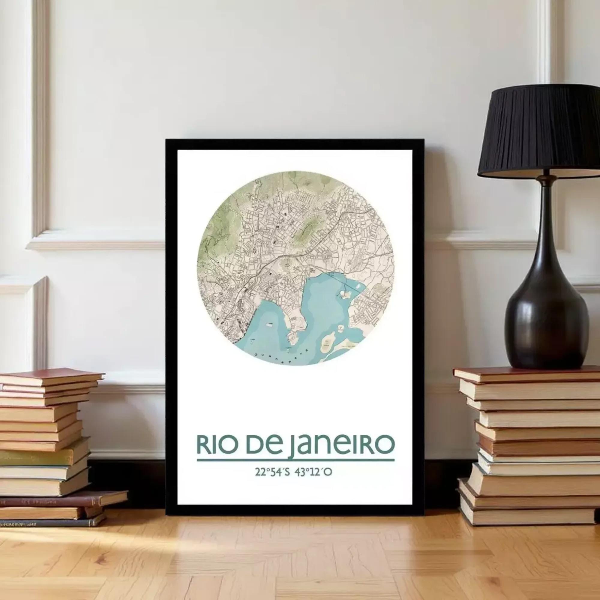 A framed map of Rio de Janeiro, Brazil, with a lamp and a stack of books on either side.