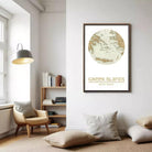 a cozy living room with a large framed map of Greek islands hanging on the wall. The room has a comfortable seating area with a chair and a bookshelf filled with books. The overall atmosphere of the room is warm and inviting, with a focus on the map and the bookshelf.