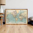 The image is a framed vintage map of the world, depicting the continents and oceans in a detailed and colorful manner.
