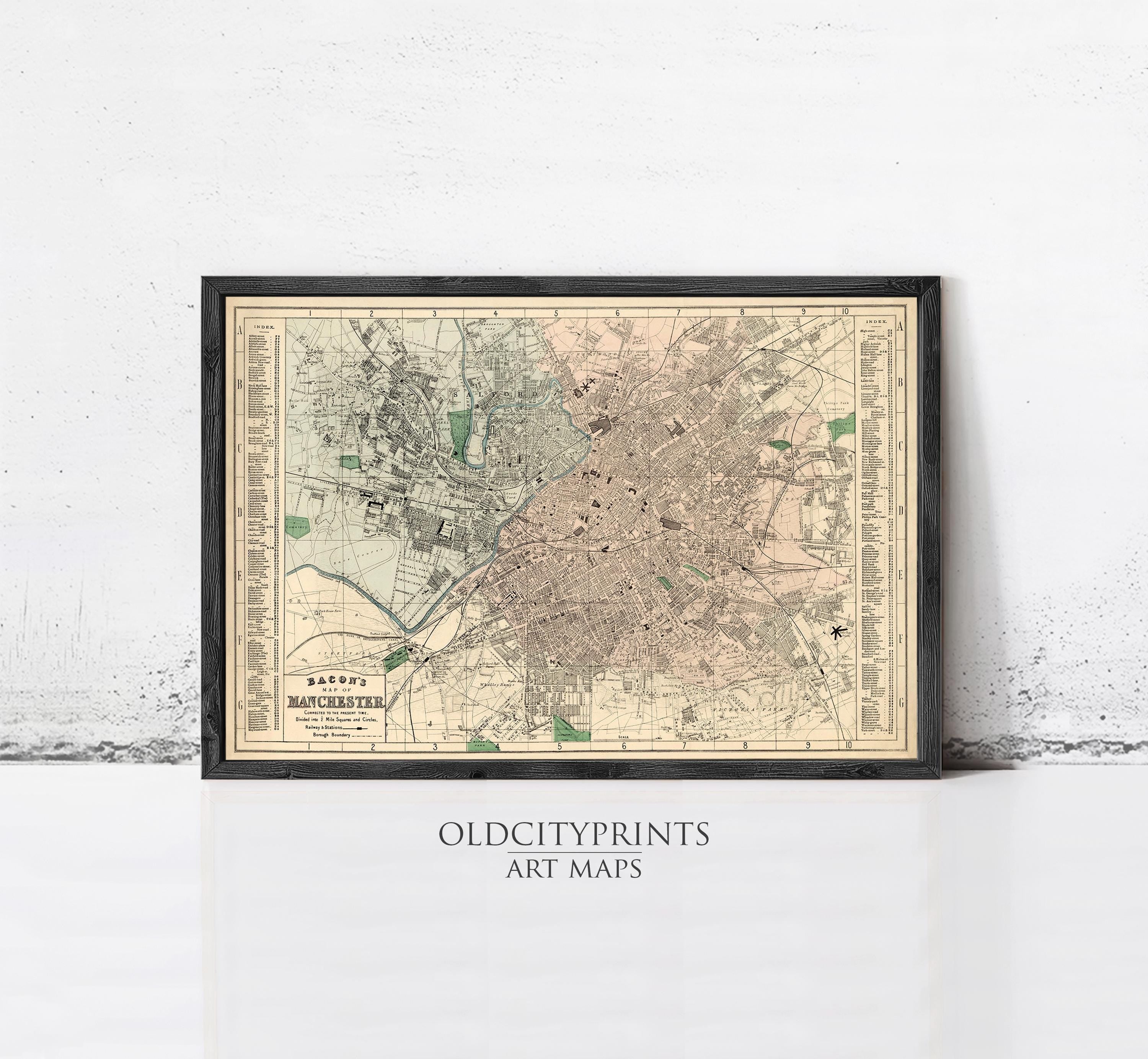 The image is a framed vintage map of a city, likely from the early 20th century, displayed on a wall.