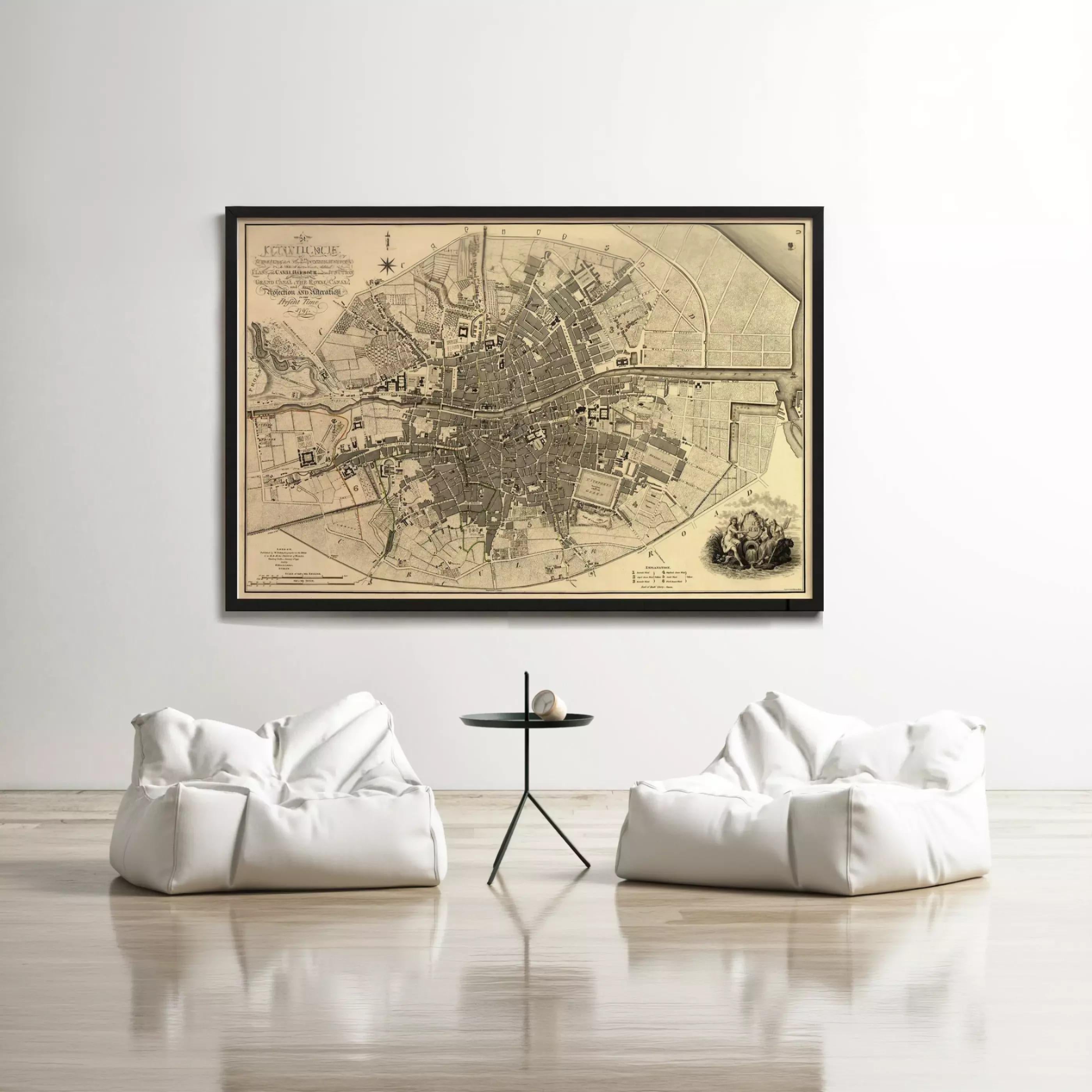 a large framed map of a city hanging on a white wall, with two white bean bag chairs positioned in front of it.