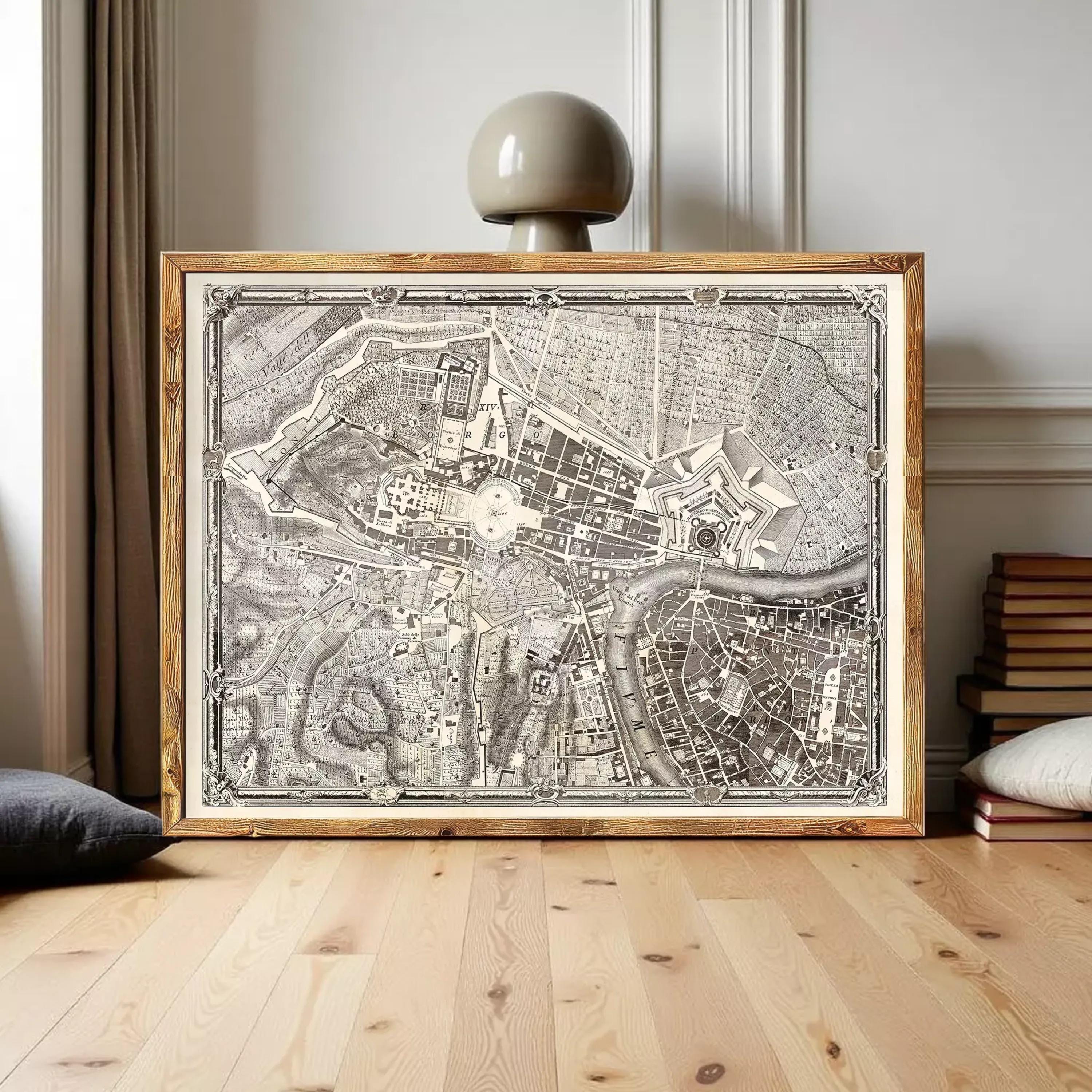 A large framed map of a city or region, with intricate details and a vintage appearance, displayed on a wooden floor in a room with books and a lamp.