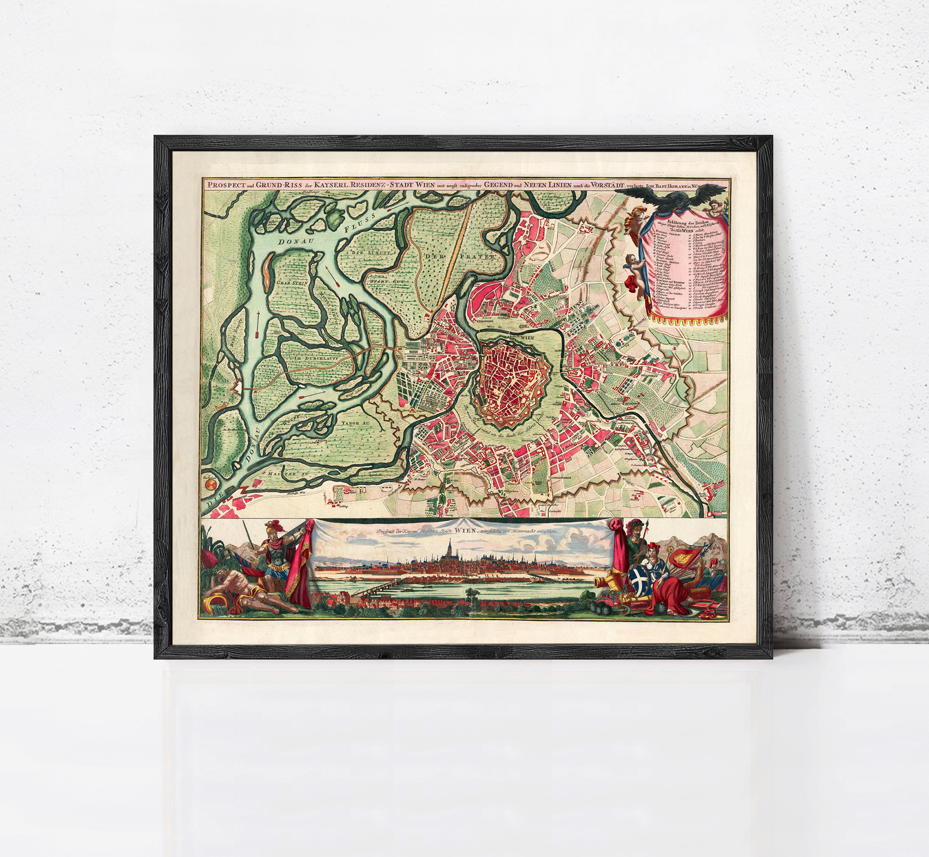 The image is a framed vintage map of a city, depicting a detailed layout of the streets, landmarks, and surrounding areas.