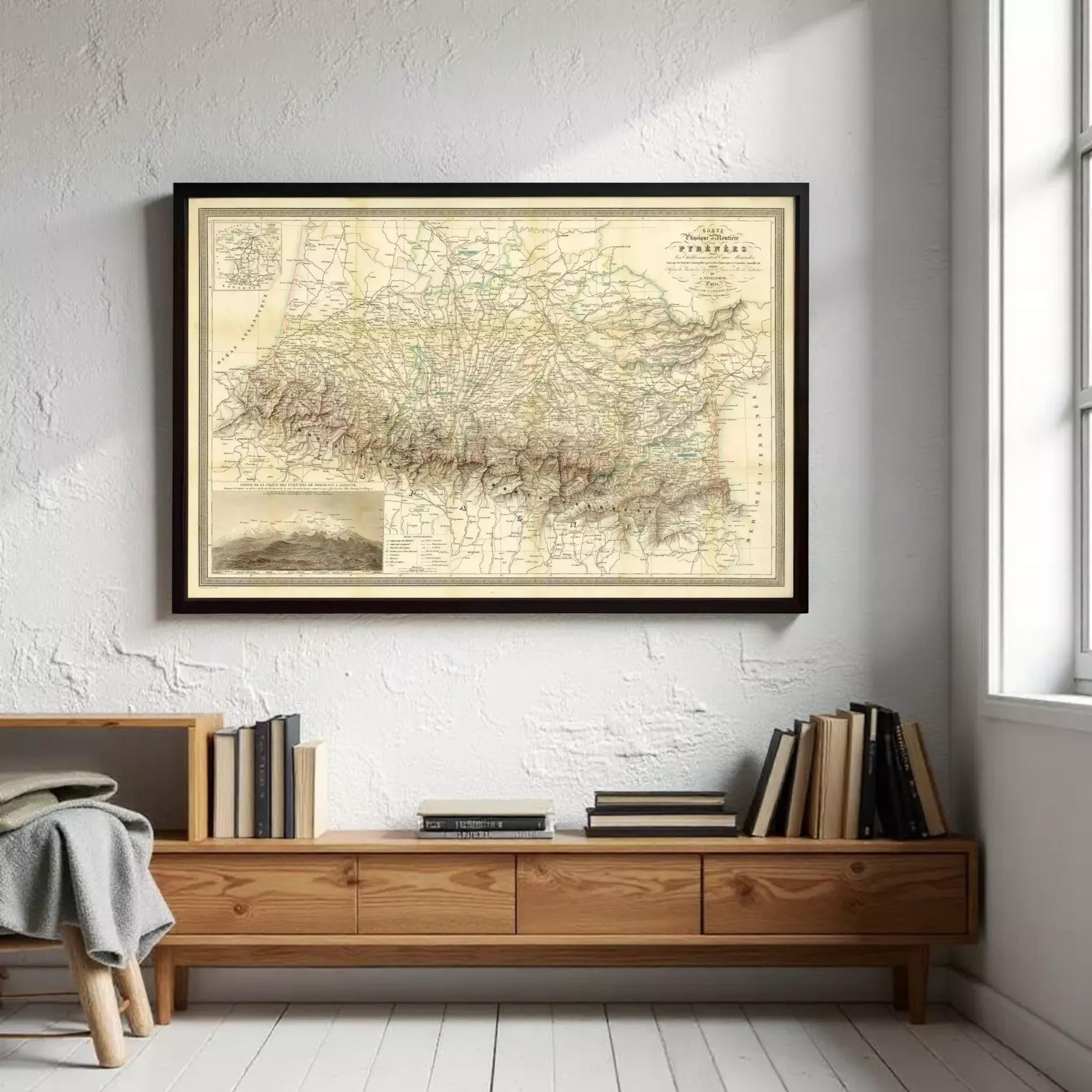 a framed map of South America hanging on a white wall above a wooden bookshelf filled with books.
