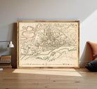The image is a framed map of the city of Warsaw, Poland, depicting the city's layout and surrounding areas.