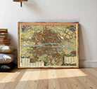 The image is a framed vintage map of a city, likely Paris, with detailed illustrations and labels.