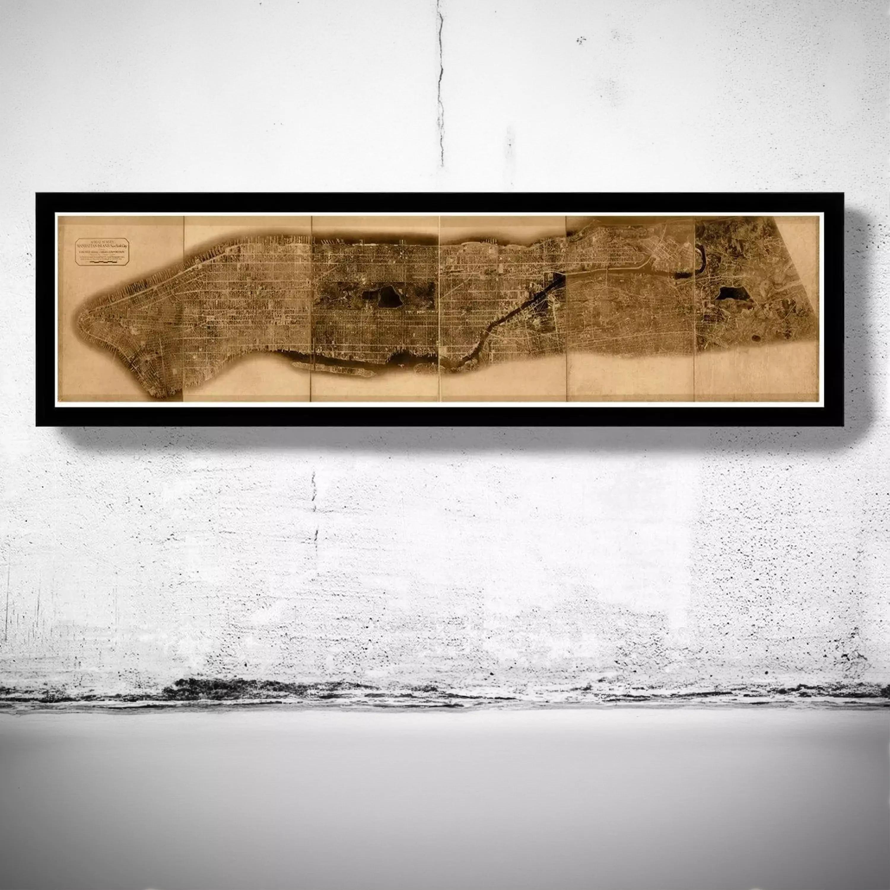 A framed map of a city or region is hanging on a wall.