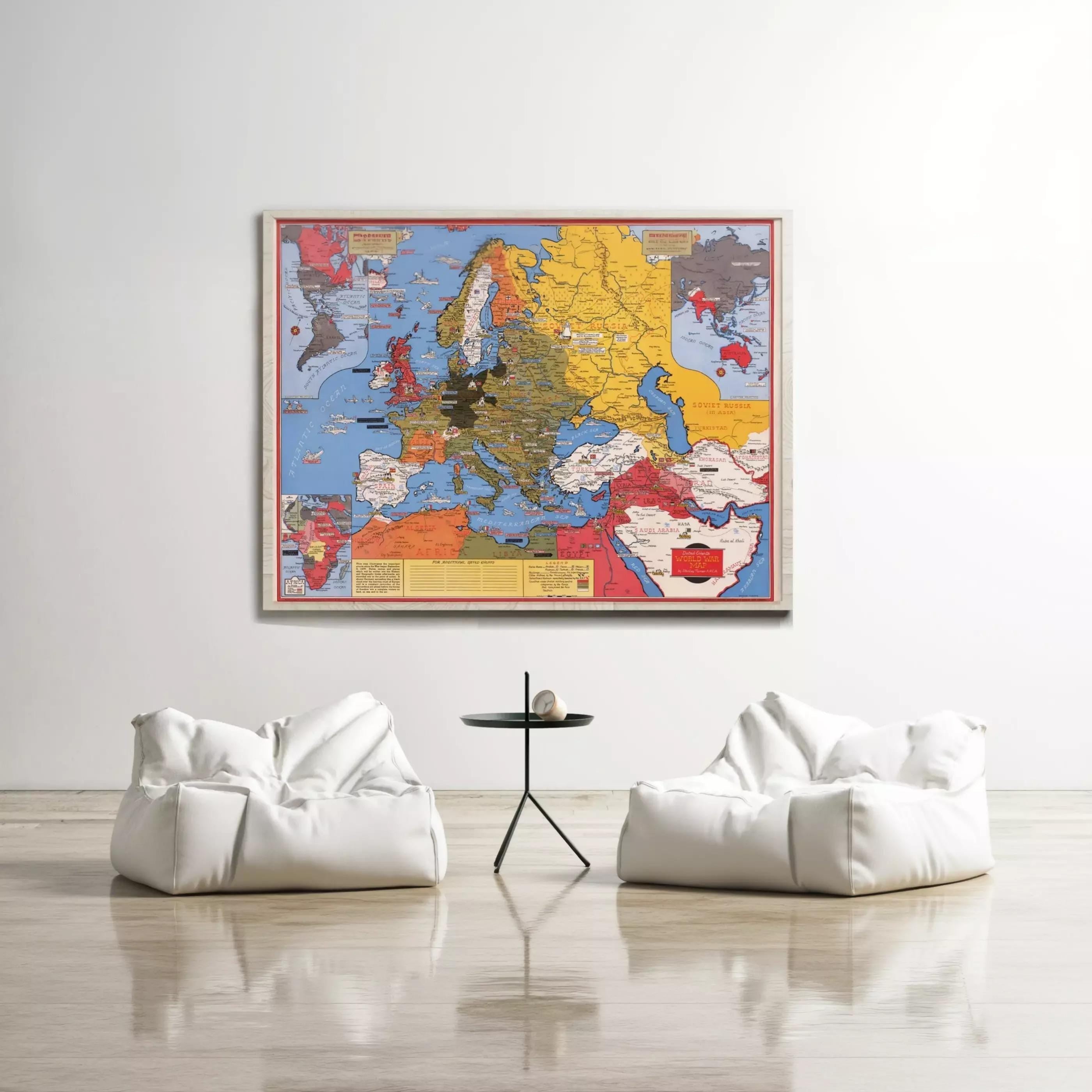 a large, colorful map of Europe hanging on a white wall, with two white bean bag chairs positioned in front of it.