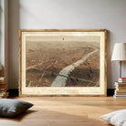 The image is a framed aerial view of a city, depicting a river or canal running through the center of the city.