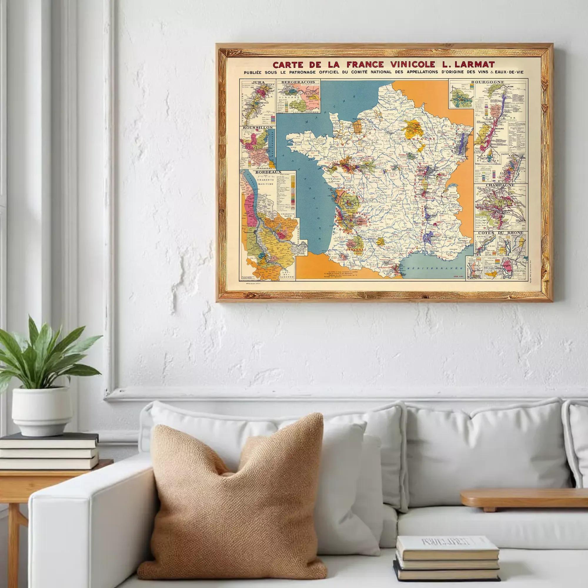a framed vintage map of France hanging on a wall above a white couch.