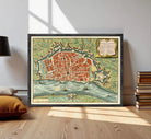 The image is a framed vintage map of a city, depicting a detailed layout of the streets, landmarks, and surrounding areas.