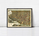 The image is a framed vintage map of a city, depicting a densely populated urban area with numerous buildings and streets.