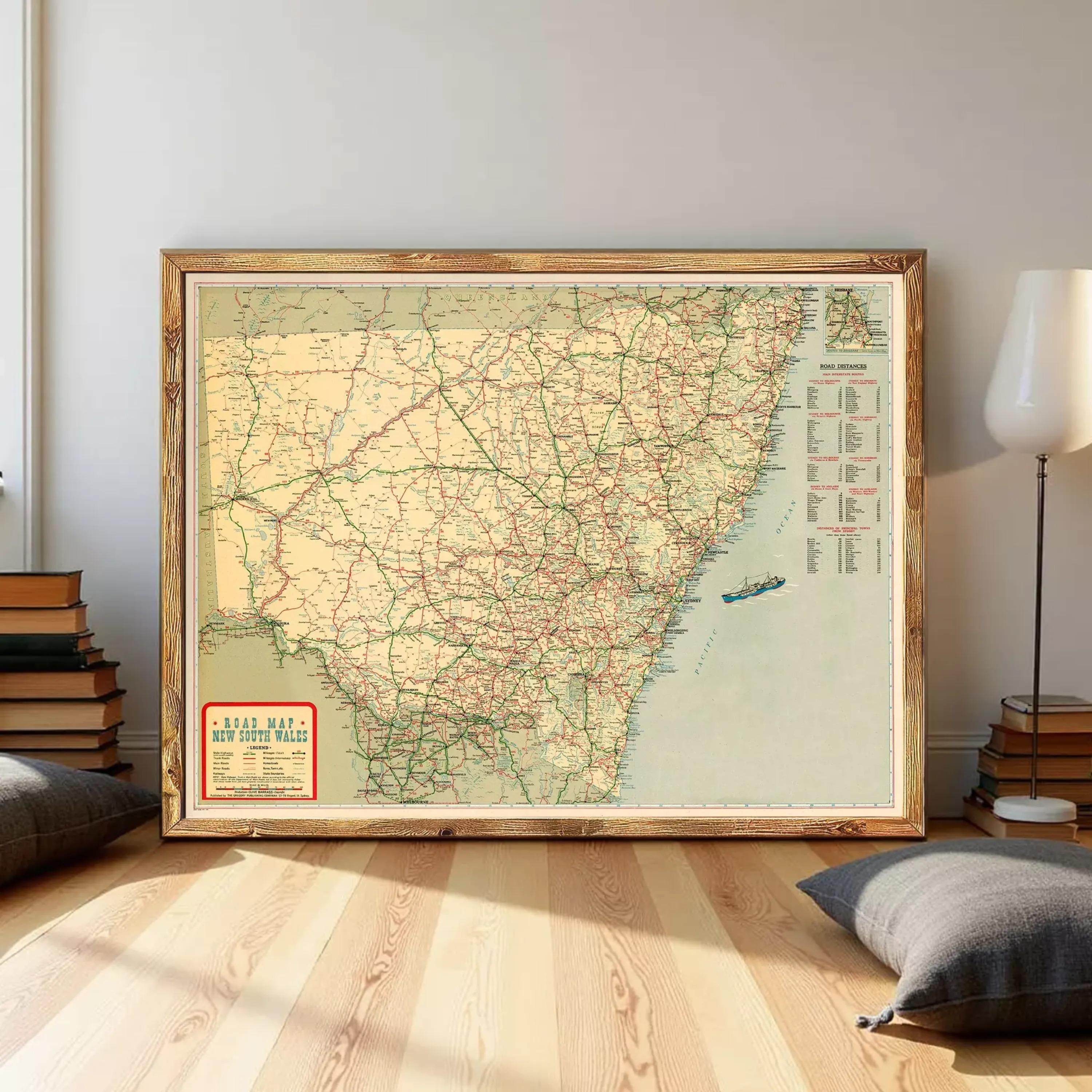 a large framed map of the New South Wales region in Australia, with a wooden floor and a stack of books visible in the background.