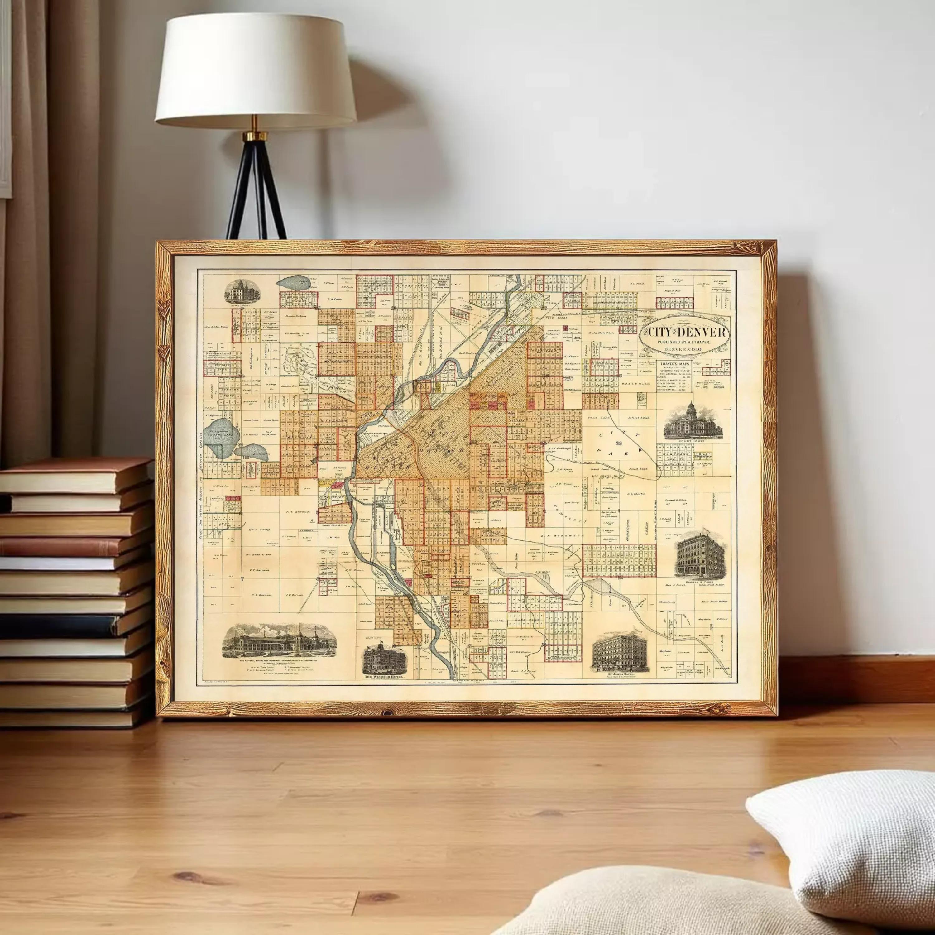 a framed map of the city of Denver, Colorado, with various landmarks and streets depicted on it.