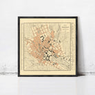 The image is a framed map of a city, likely from the 19th century, depicting a detailed layout of the streets and surrounding areas.