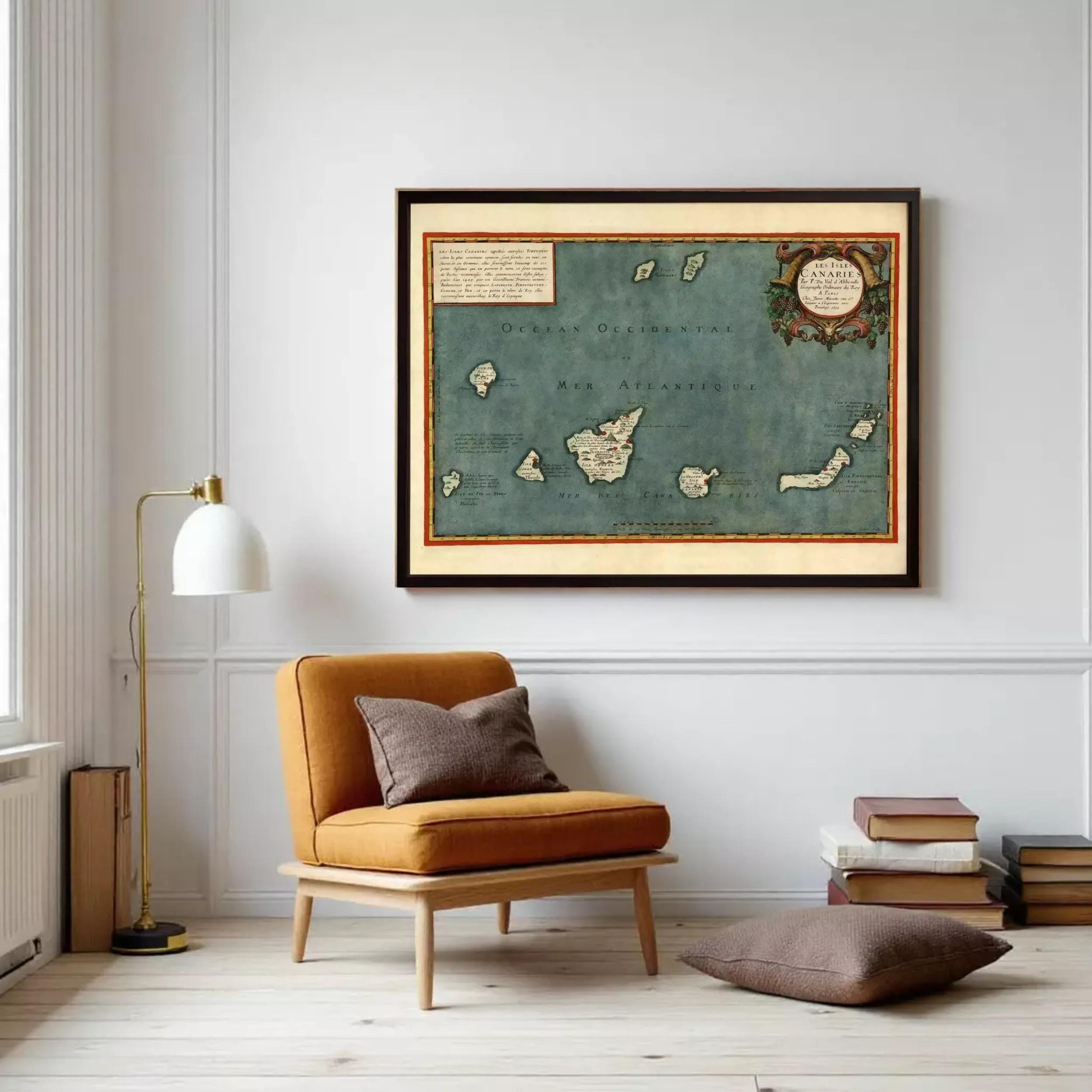 a cozy living room with a large framed map of the Caribbean hanging on the wall, a comfortable brown armchair, a stack of books, and a lamp on a side table.