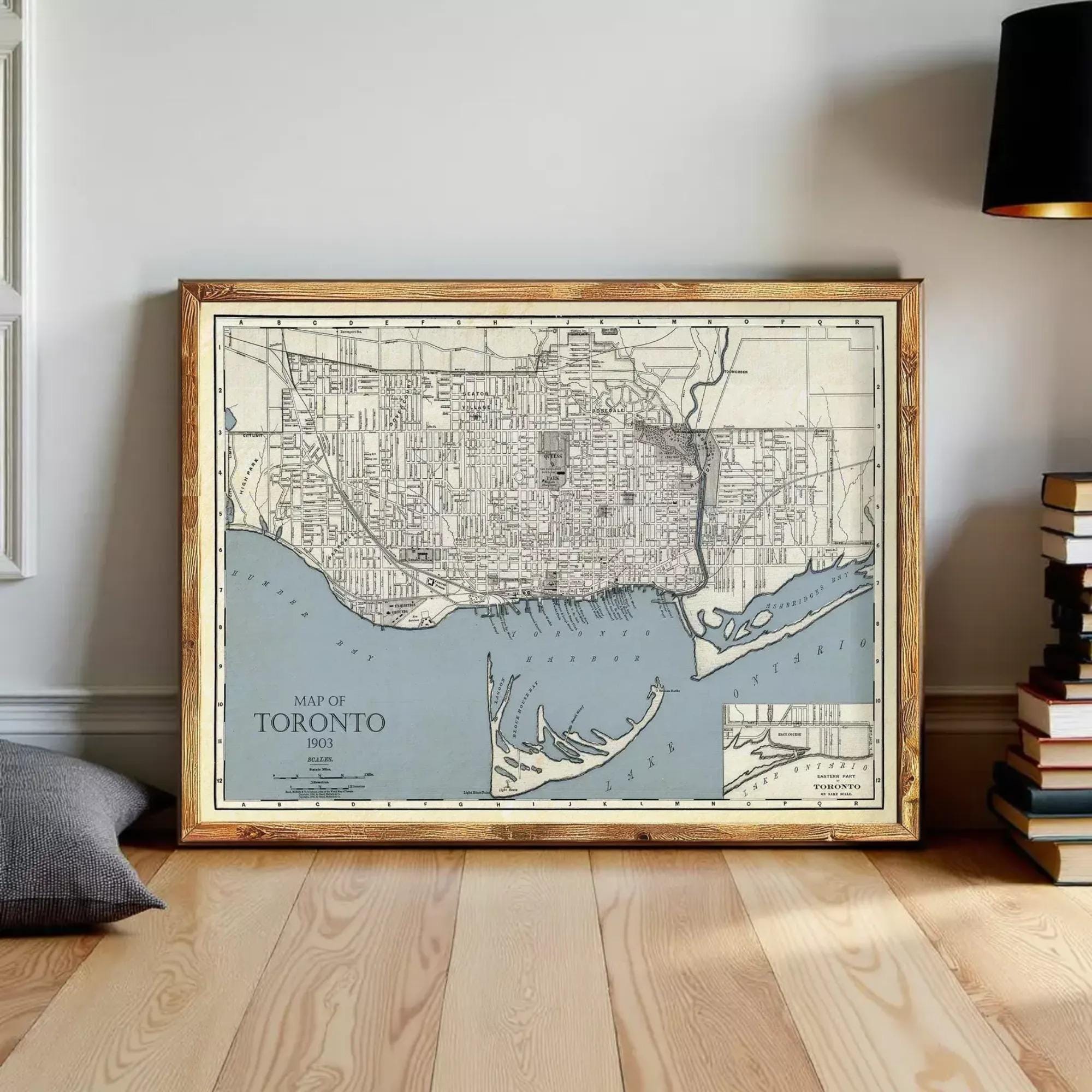 A framed map of Toronto, Canada, depicting the city's streets and surrounding areas, is displayed on a wooden floor.